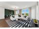 Open-concept living area with stylish decor, large sectional sofa, modern lighting, and scenic views through the windows at 10622 Pleasant Branch Dr # 8, Raleigh, NC 27614