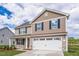 Two-story home showcasing a two-car garage, covered porch, vinyl siding, and well-maintained landscaping at 109 Wilderness Ct, Mebane, NC 27302