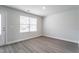 Bright, empty room with vinyl flooring, with an open window, and door to the outside at 109 Wilderness Ct, Mebane, NC 27302