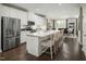 Bright kitchen with white cabinets, stainless steel appliances, a large island with seating, and open dining area at 1210 Tannin Dr, Durham, NC 27713