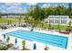 Aerial shot of a large community pool surrounded by greenery, lounge chairs, umbrellas, and a clubhouse at 1210 Tannin Dr, Durham, NC 27713