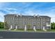 Exterior view of modern gray townhomes featuring white trim, tidy landscaping, and a well-maintained facade at 1210 Tannin Dr, Durham, NC 27713
