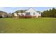 Rear exterior of a home with a large yard, deck, sliding glass doors and mature trees at 123 Glasgow Dr, Clayton, NC 27520