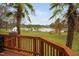 Scenic backyard view with a pond, palm trees, a charming white shed and an inviting wooden deck at 123 Glasgow Dr, Clayton, NC 27520