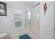 Bathroom with tiled shower/tub, window, and a decorative parrot on the wall at 123 Glasgow Dr, Clayton, NC 27520