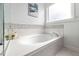 Relaxing bathroom featuring an alcove tub with mosaic tile surround at 123 Glasgow Dr, Clayton, NC 27520