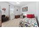 Quaint bedroom with patterned carpet, colorful bedding, and a window with curtains at 123 Glasgow Dr, Clayton, NC 27520