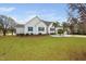 Charming white home with blue shutters, a well-manicured lawn, and mature trees in a residential neighborhood at 123 Glasgow Dr, Clayton, NC 27520