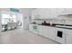 Well-lit kitchen featuring white cabinetry, modern appliances, and a view into the dining area at 123 Glasgow Dr, Clayton, NC 27520