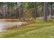 Scenic pond view with geese, trees, a dock, and lush greenery, offering a serene natural setting at 123 Glasgow Dr, Clayton, NC 27520