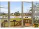 Enclosed sunroom with large windows overlooking the lake and a wooden deck at 123 Glasgow Dr, Clayton, NC 27520