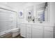 Bright bathroom featuring a double sink vanity, framed mirrors, and a glass-enclosed shower at 133 Cavalier Rider Run, Wendell, NC 27591