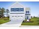 Charming two-story home featuring light blue siding, a two-car garage, and blue shutters at 133 Cavalier Rider Run, Wendell, NC 27591
