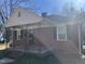 Close-up view of brick home, showing front porch with black metal supports at 1411 Hudson Ave, Durham, NC 27705