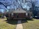 Charming brick home with a covered porch and well-maintained front yard at 1411 Hudson Ave, Durham, NC 27705