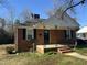 Quaint brick home featuring a cozy front porch and neat landscaping at 1411 Hudson Ave, Durham, NC 27705