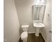 This half bathroom includes a toilet and pedestal sink with a framed mirror above it at 157 W Copenhaver Dr, Clayton, NC 27527