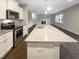 This kitchen features stainless steel appliances, granite countertops, and a view of the living room at 157 W Copenhaver Dr, Clayton, NC 27527