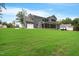 Expansive backyard with lush lawn, outdoor fireplace, and screened porch at 1600 Sweetwater Ln, Raleigh, NC 27610