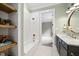 Bathroom with a soaking tub, marble countertop, bronze fixtures, and open shelving at 1600 Sweetwater Ln, Raleigh, NC 27610