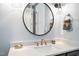 Modern bathroom vanity featuring a round mirror and brushed gold fixtures at 1600 Sweetwater Ln, Raleigh, NC 27610