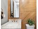 Stylish bathroom featuring modern fixtures, marble countertop, and unique wood paneled accent wall at 1600 Sweetwater Ln, Raleigh, NC 27610