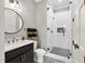 Bathroom features a glass shower, round mirror, and modern black and white patterned floors at 1600 Sweetwater Ln, Raleigh, NC 27610