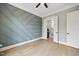 Bedroom with modern accent wall, ceiling fan, hardwood floors and attached bathroom at 1600 Sweetwater Ln, Raleigh, NC 27610