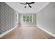 Spacious bedroom with hardwood floors, modern ceiling fan, and unique herringbone accent wall at 1600 Sweetwater Ln, Raleigh, NC 27610