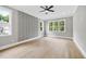 Bright bedroom with hardwood floors, large windows offering serene views, and unique herringbone accent wall at 1600 Sweetwater Ln, Raleigh, NC 27610