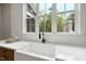 The kitchen features a farmhouse sink with modern faucet under a bright window with a view of the outdoors at 1600 Sweetwater Ln, Raleigh, NC 27610