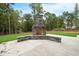 Stone outdoor fireplace with a concrete patio at 1600 Sweetwater Ln, Raleigh, NC 27610