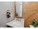 This powder room features a wood accent wall, granite countertop, and modern fixtures at 1600 Sweetwater Ln, Raleigh, NC 27610