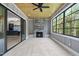 Sunroom featuring stone fireplace, large windows and sliding glass door to basement bar at 1600 Sweetwater Ln, Raleigh, NC 27610