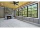 Sunroom with large windows, wood ceiling, stone fireplace, and tiled floor at 1600 Sweetwater Ln, Raleigh, NC 27610