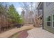 Backyard featuring lush greenery, brick paver patio, and wooded area at 1680 Mint River Dr, Apex, NC 27502