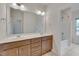 Bathroom featuring a double vanity, a large mirror, and a tub and shower at 1680 Mint River Dr, Apex, NC 27502