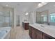 Bright bathroom featuring dual vanities, a glass-enclosed shower, and a soaking tub at 1680 Mint River Dr, Apex, NC 27502