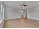 Spacious bedroom featuring hardwood floors, a ceiling fan, and natural light from a large window at 1680 Mint River Dr, Apex, NC 27502