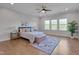 Bright bedroom with three windows, ceiling fan, and a rug underneath the bed at 1680 Mint River Dr, Apex, NC 27502