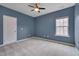 Cozy bedroom showcasing blue walls, carpeted floors, and a bright window at 1680 Mint River Dr, Apex, NC 27502
