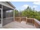 View of wooden deck with stairs, connected to screened in porch with treeline in background at 1680 Mint River Dr, Apex, NC 27502