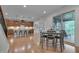 Open-concept dining area with wood floors that connects to the modern kitchen and screened in back porch at 1680 Mint River Dr, Apex, NC 27502