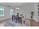 Bright dining room features modern chandelier, hardwood floors, and large windows at 1680 Mint River Dr, Apex, NC 27502