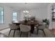 Elegant dining room with stylish decor, a modern chandelier, and large windows at 1680 Mint River Dr, Apex, NC 27502