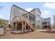 Multi-story home with a deck, patio, fenced yard, and lush landscaping at 1680 Mint River Dr, Apex, NC 27502