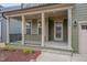 Inviting front porch with classic columns and black railings, leading to the front door at 1680 Mint River Dr, Apex, NC 27502