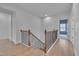 Upstairs hallway with wooden floors and black iron railing, leading to bedrooms at 1680 Mint River Dr, Apex, NC 27502