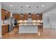 Spacious kitchen with stainless steel appliances, a center island, and wooden cabinetry providing ample space at 1680 Mint River Dr, Apex, NC 27502