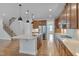 Bright, open kitchen featuring a large center island, stainless steel appliances, and hardwood flooring, exuding modern elegance at 1680 Mint River Dr, Apex, NC 27502